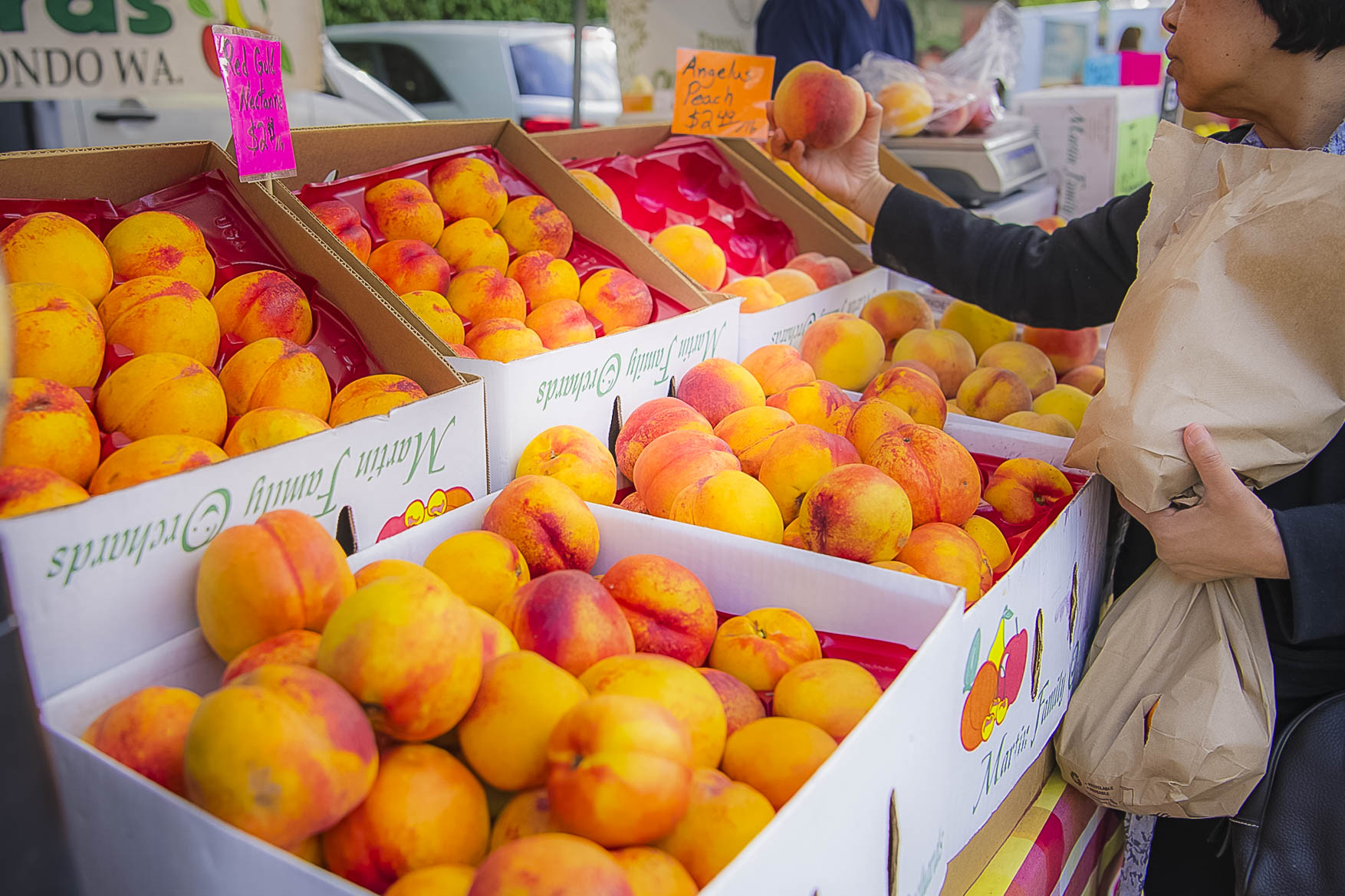Fruit products in a farmer market. Customer is holding the products. Commercial photographer in Yakima Valley, WA.