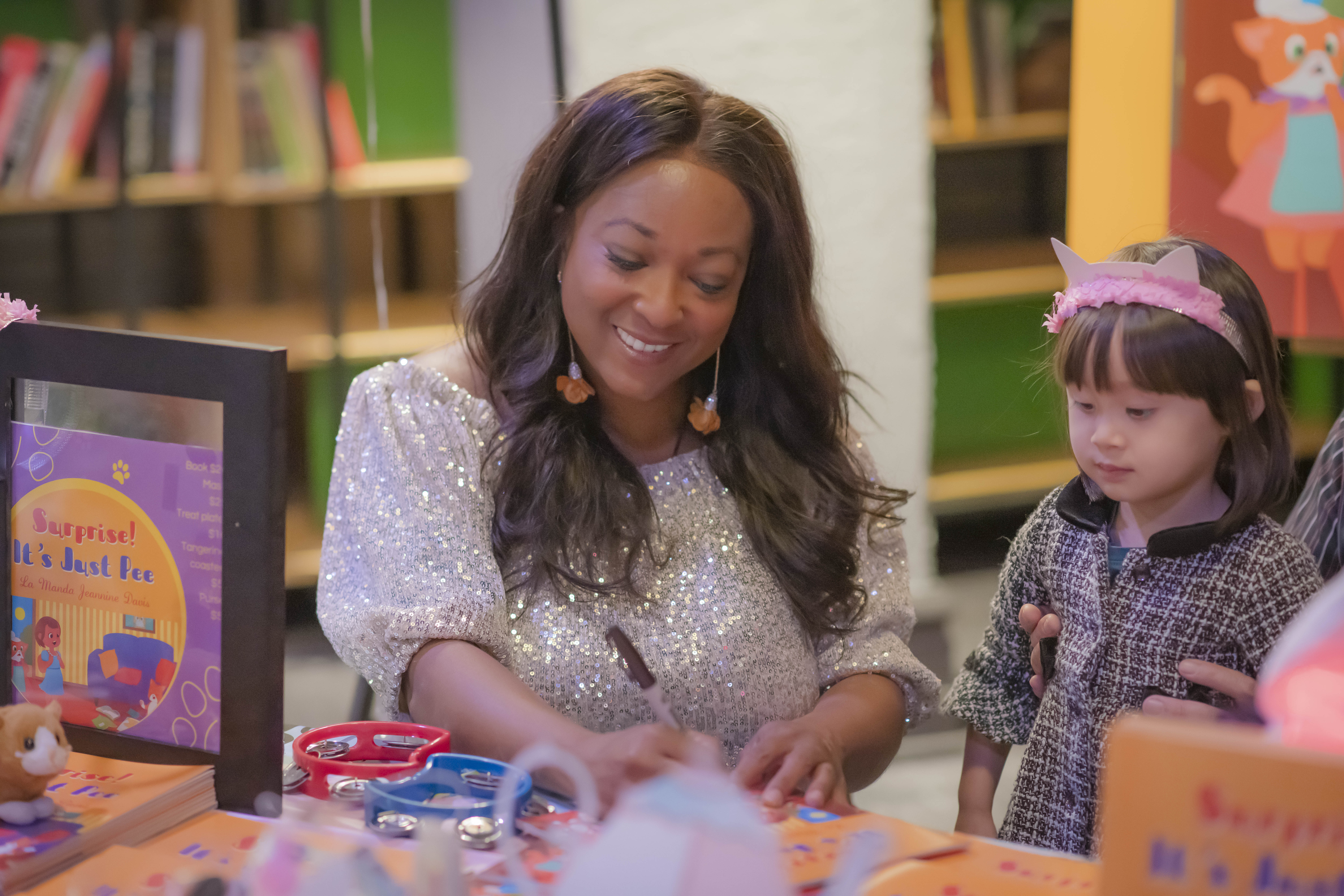 A children book author signing book for a kid. Commercial photographer by Kiss of Heaven Photography.