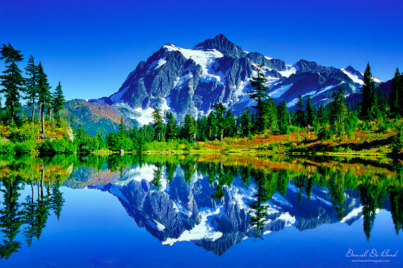 Mount Shuksan reflected almost perfectly in a still pond during peak autumn, surrounded by vibrant fall colors — a fine art nature photograph symbolizing hope and healing.