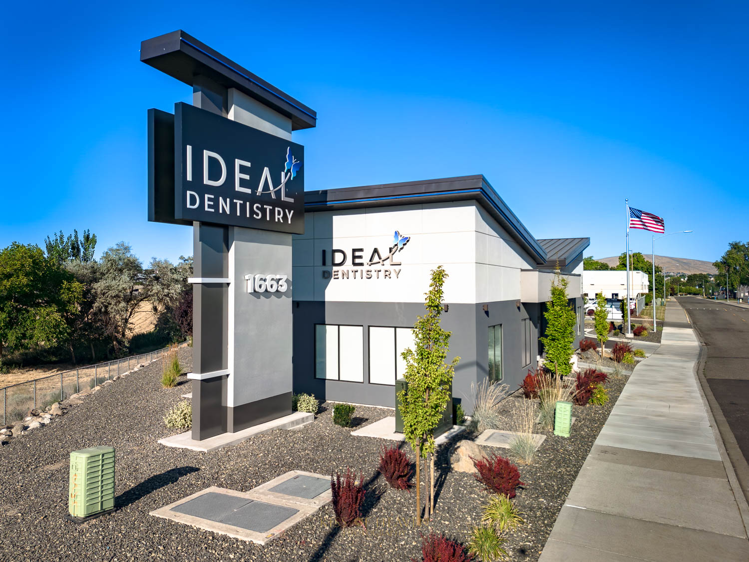 Exterior area of IDEAL DENTISTRY with its sign, a modern dental clinic in Richland, WA. Commercial photographer by Kiss of Heaven Photography.