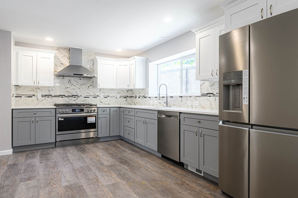 A modern kitchen shows new stove and new refrigerator